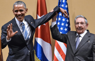 記者会見で、オバマ米大統領（左）の左手を持ち上げるキューバのラウル・カストロ国家評議会議長＝2016年3月21日、ハバナ【ＡＦＰ時事】