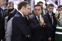 北フランスのルノー工場を訪れたマクロン大統領（手前左）と話すカルロス・ゴーン同社会長兼最高経営責任者（CEO）＝2018年11月8日、仏モブージュ【AFP時事】