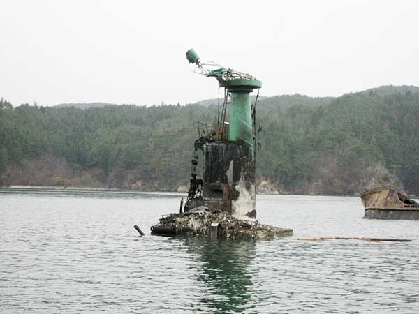 気仙沼市、番所根灯標。焼け焦げた灯台が見える（宮城県気仙沼市）〔海上保安庁提供〕