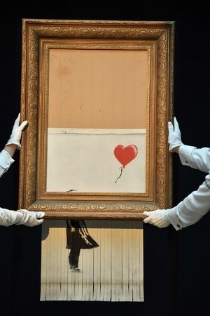 バンクシーの作品「少女と風船」の一部が細断された作品「愛はごみ箱の中に」＝２０１８年１０月、ロンドン（ＡＦＰ時事）