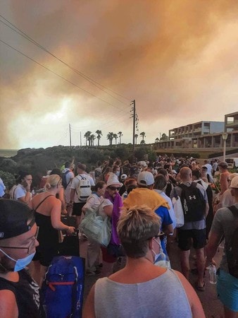 ２２日、ギリシャ・ロードス島で山火事から避難する観光客（ＡＦＰ時事）
