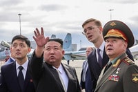 １６日、ロシア極東ウラジオストク郊外の飛行場をショイグ国防相（右）と視察する北朝鮮の金正恩朝鮮労働党総書記（左から２人目）（ロシア国防省提供）（ＡＦＰ時事）