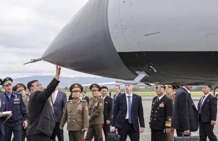 １６日、ロシア極東ウラジオストク郊外の飛行場で、極超音速ミサイルシステム「キンジャル」の一部である戦闘機に触れる北朝鮮の金正恩朝鮮労働党総書記（左）（ＥＰＡ時事）