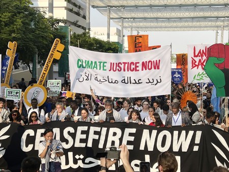 ９日、アラブ首長国連邦（ＵＡＥ）のドバイで開催中の国連気候変動枠組み条約第２８回締約国会議（ＣＯＰ２８）の会場で、大規模デモを行う環境ＮＧＯや市民団体などのメンバーら