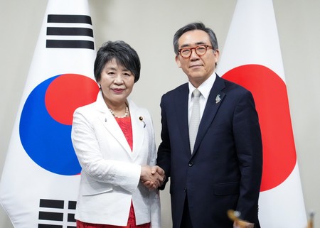 握手する上川陽子外相（左）と韓国の趙兌烈外相＝２１日、ブラジル・リオデジャネイロ（外務省提供）