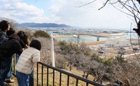 宮城県石巻市の高台にある日和山公園から旧北上川河口付近を眺める家族ら＝１０日午後