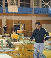指導に当たる佐原ジュニア体操クラブの山岸信行さん。左奥のバスケットゴールからつり輪がつるされている＝４月１９日、千葉県香取市