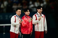 体操男子個人総合の表彰式で金メダルを手にする岡慎之助（中央）＝７月３１日、パリ（ＡＦＰ時事）